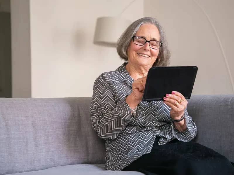 Older adult checking calendar dates on a tablet device at home